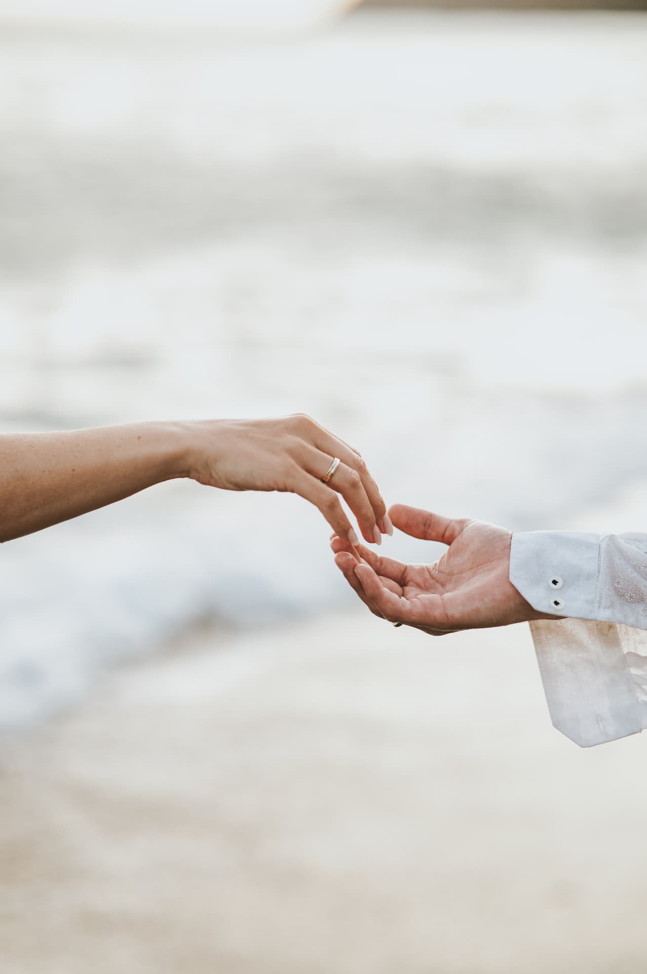 Two hands reaching for one another above the water