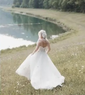 Bride twirling by a mountain lake